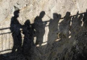 Schatten von ein Menge von Menschen auf ein Cliff foto