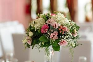 Luxus Urlaub oder Hochzeit Tisch, reich dekoriert mit schön Blumen- Blumensträuße. Blumen- Kompositionen mit frisch Rosen. foto