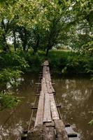 alte Holzbrücke, Holzbrücke über einen kleinen Fluss, Brücke mit der Natur. foto