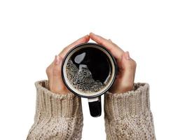 Frau hält Tasse heißen Kaffee isoliert auf Weiß, Nahaufnahmefoto von Händen im warmen Pullover mit Becher, Wintermorgenkonzept, Draufsicht foto