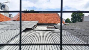 Aussicht von das Dach von das alt Haus und das Blau Himmel. gesehen von hinter ein Eisen Gitter. selektiv Fokus. foto