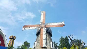 Windmühle Bauernhaus mit langsam rotierend Klingen oder Propeller. ein klar Blau Himmel im Hintergrund. foto