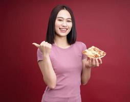 jung asiatisch Frau Essen Pizza auf Hintergrund foto