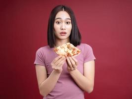 jung asiatisch Frau Essen Pizza auf Hintergrund foto