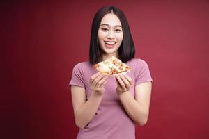 jung asiatisch Frau Essen Pizza auf Hintergrund foto