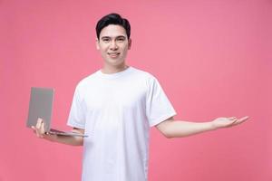 jung asiatisch Mann halten Laptop auf Hintergrund foto