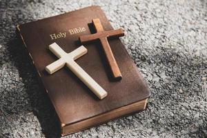 Nahaufnahme von einfachen hölzernen christlichen Kreuzen auf einer Bibel foto