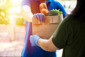 Foodservice-Anbieter mit Masken und Handschuhen. Zu Hause bleiben reduziert die Ausbreitung des Covid-19-Virus foto