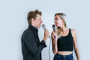 glückliches Porträt des Paares, das Mikrofone hält und singt
