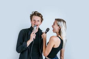 glückliches Porträt des Paares, das Mikrofone hält und singt