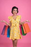 schöne asiatische Frau, die farbige Einkaufstaschen hält
