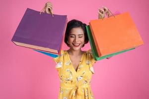 schöne asiatische Frau, die farbige Einkaufstaschen hält