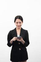 Porträt der selbstbewussten Geschäftsfrau unter Verwendung des Mobiltelefons lokalisiert auf weißem Hintergrund foto