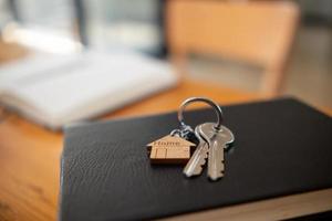 Haus Schlüssel sind platziert im echt Nachlass Büro bereit zu Sein übergeben Über zu Kunde Wer unterzeichnet echt Nachlass Vertrag innerhalb das Büro. Konzept von Zuhause Lieferung zu Kunden nach Vertragsabschluss. foto