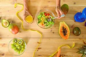 Frau bereitet vor ein gesund Mahlzeit mit Salat und Orange Saft foto