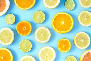 Sammlung von frischen Limetten-, Zitronen-, Orangen-, Zitrus-, Grapefruitscheiben auf blauem Hintergrund.