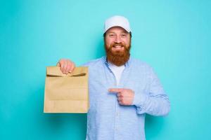 Lieferant mit glücklich Ausdruck ist bereit zu liefern ein Essen Paket foto