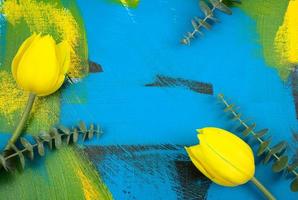 frische gelbe Tulpen mit Eukalyptusblättern lagen flach auf bunter Zusammenfassung foto