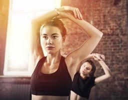 Freund Mädchen tun Dehnen beim das Fitnessstudio foto