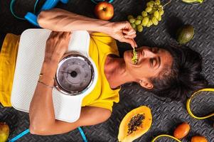 glücklich Frau Essen gesund und Züge im das Fitnessstudio foto