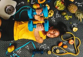 glücklich Frau Essen gesund und Züge im das Fitnessstudio foto