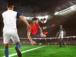 Fußball Stürmer im rot und Blau Uniform Treffer das Ball mit ein Kopf Schuss im das Luft beim das Stadion foto
