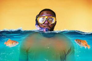 Mann mit Schnorcheln Maske ist erschrocken zu gehen unter Wasser. Gelb Hintergrund foto