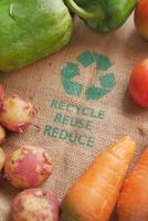 Recycling-Pfeile-Zeichen auf einer Einkaufstasche mit Gemüse foto