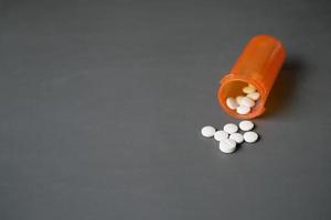 Weiße medizinische Pillen, die auf Rosa verschüttet werden foto