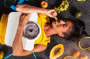 glücklich Frau Essen gesund und Züge im das Fitnessstudio foto