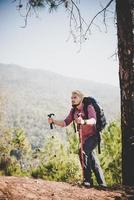 Mann Reisender mit Rucksack, der die Karte beim Bergsteigen betrachtet
