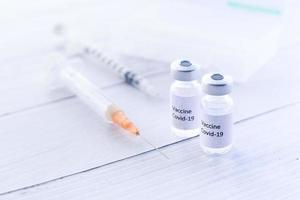 Nahaufnahme des Coronavirus-Impfstoffs und der Spritzen auf weißem Hintergrund