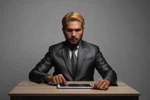 Geschäftsmann, der auf digitalem Tablett berührt und auf einem leeren Bildschirm schaut foto