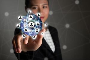 Geschäftsfrau, die moderne Technologie-Schnittstelle mit 3D-Symbolen berührt foto