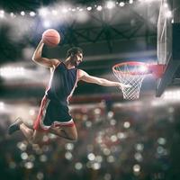 akrobatisch zuschlagen Dunk von ein Korb Spieler im das Korb beim das Stadion foto