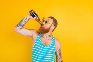 Mann mit Bart und Sonnenbrille Getränke Bier foto