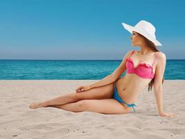 Mädchen im Bikini Sonnenbaden auf Strand foto