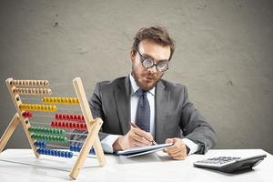 Nerd Buchhalter tut Berechnung von Unternehmen Einnahmen foto