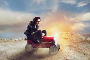 Geschäftsfrau fährt ein Spielzeug Wagen. Konzept von Wettbewerb und Entschlossenheit foto