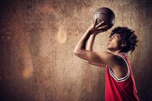 Basketball Spieler wirft das Ball auf Grunge braun Hintergrund foto