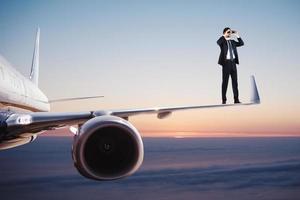 Geschäftsmann mit Fernglas Über ein Flugzeug sucht zum Neu Geschäft Chancen foto