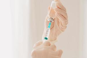 Arzt mit Spritze ist bereit zu verwalten das Impfstoff gegen covid-19 foto