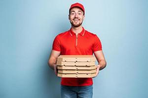 glücklich Lieferant glücklich zu liefert Pizza mit Erfolg. cyan Hintergrund foto