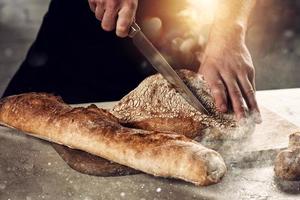 Bäcker mit Brot gerade aus von das Ofen foto