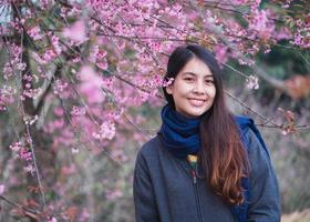 jung asiatisch Frau mit wild Himalaya Kirsche Blühen im das Garten auf Frühling foto