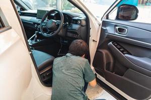 Mechaniker Mann Überprüfung und Installation Strich Nocken Gerät mit Draht Innerhalb ein Auto beim Garage foto