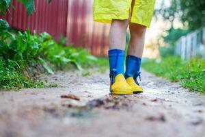 Kind im Gummi Stiefel Gehen draussen. Kinder Füße im ein Gummi Stiefel foto