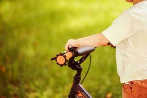 Junge mit ein Fahrrad auf das Straße foto