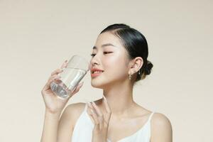 ziemlich jung Frau Trinken Wasser von Glas foto