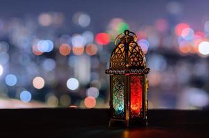 laterne mit nachthimmel und stadt bokeh heller hintergrund für das muslimische fest des heiligen monats ramadan kareem. foto